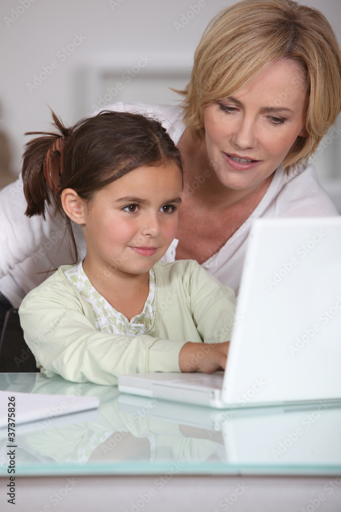 mother showing her little girl how to use the laptop mother showing her little girl how to use the laptop