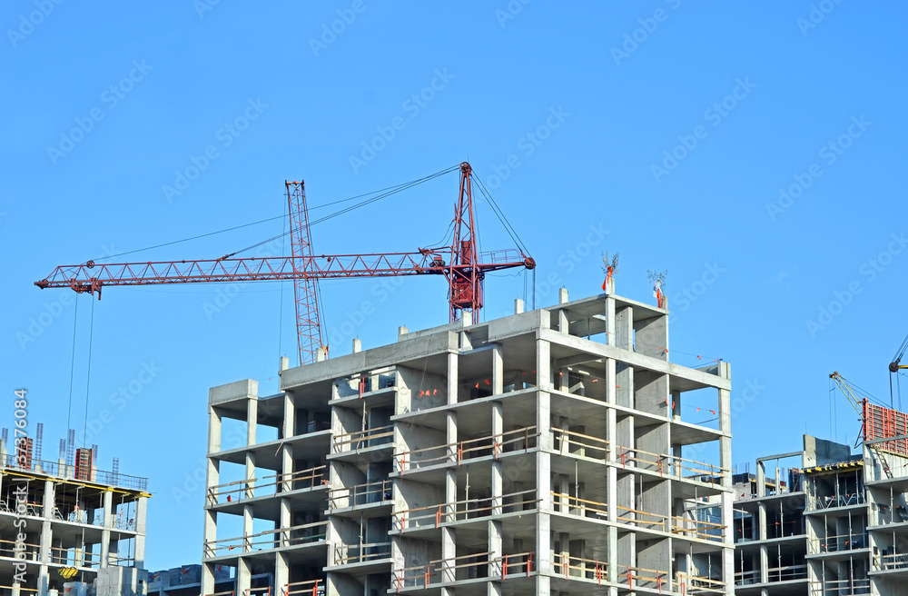 Crane and building construction site against blue sky Crane and building construction site against blue sky