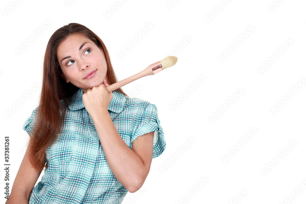 Creative woman holding an artist's paintbrush Creative woman holding an artist's paintbrush