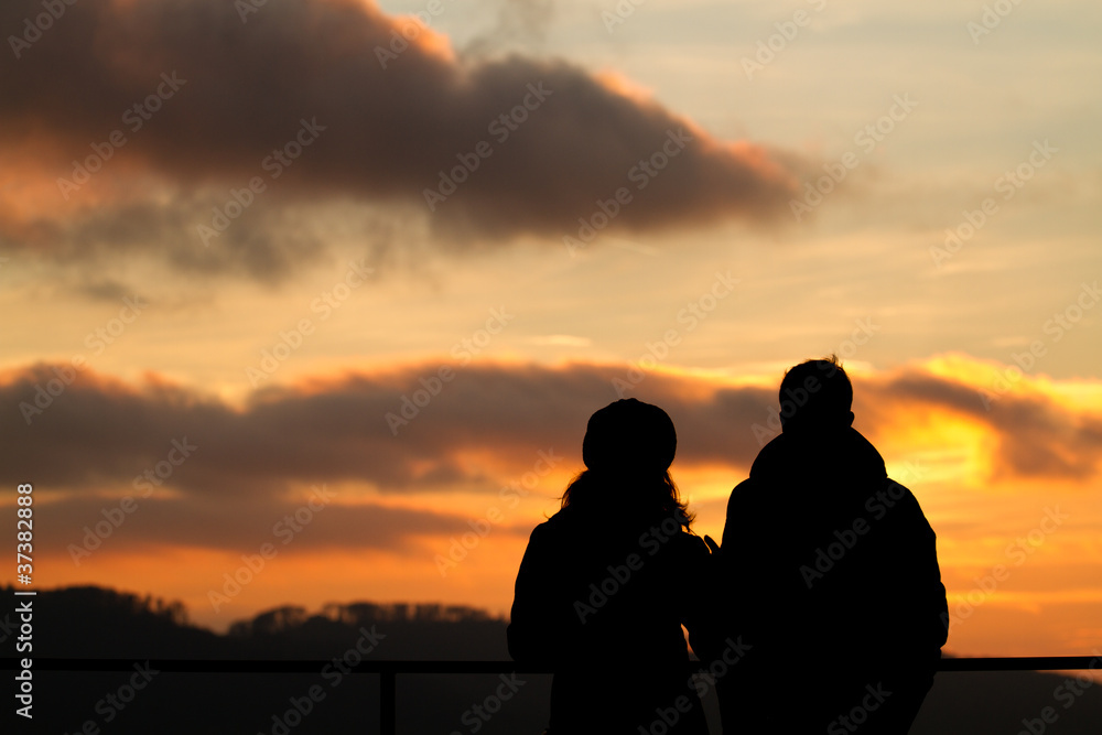silhouette of couple watching sunset