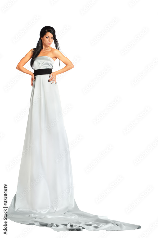 woman wearing very long silver dress stands and looks woman wearing very long silver dress stands and looks