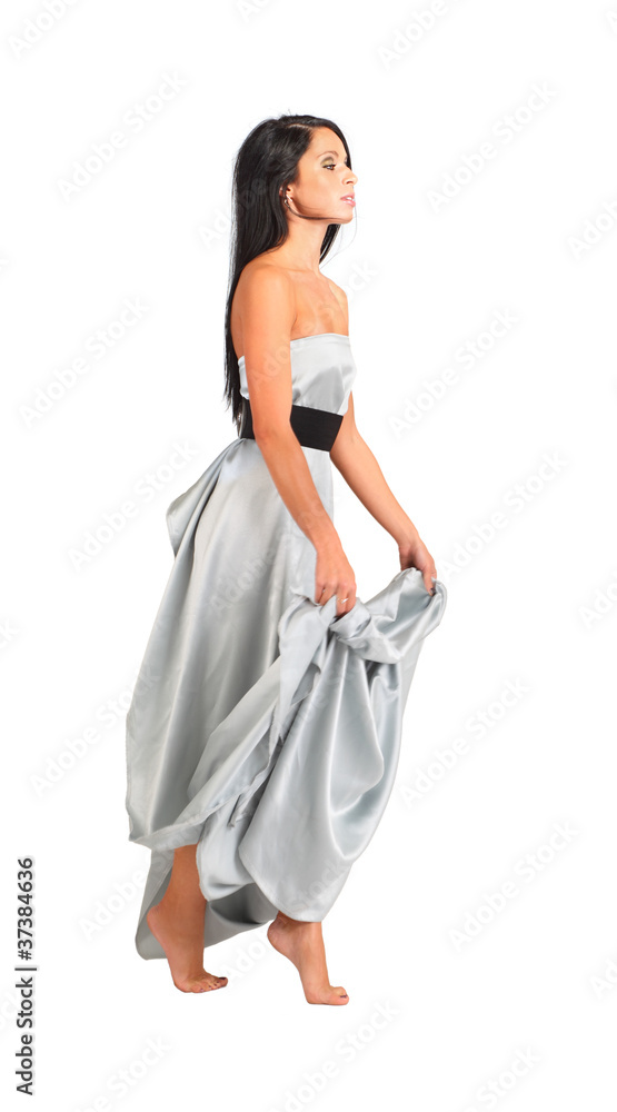 beautiful woman wearing long silver dress goes on tiptoe