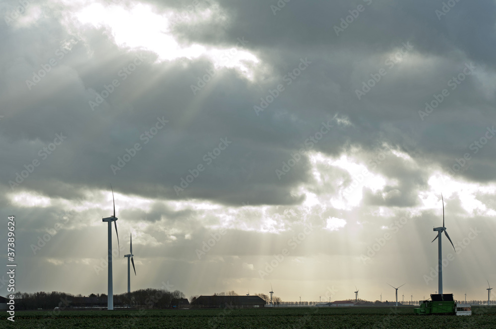 Sunbeams over farm and wind turbines Sunbeams over farm and wind turbines