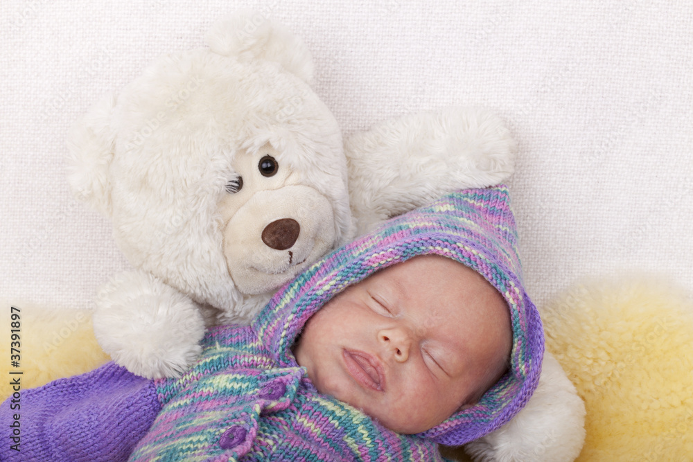 baby girl sleeping on a sofa with her teddy bear. baby girl sleeping on a sofa with her teddy bear.