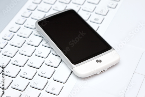 smart phone over white keyboard