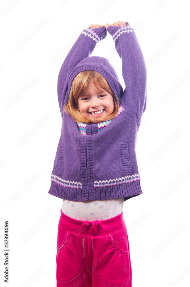 Pretty little girl smiles and holds her hands high in the air Pretty little girl smiles and holds her hands high in the air