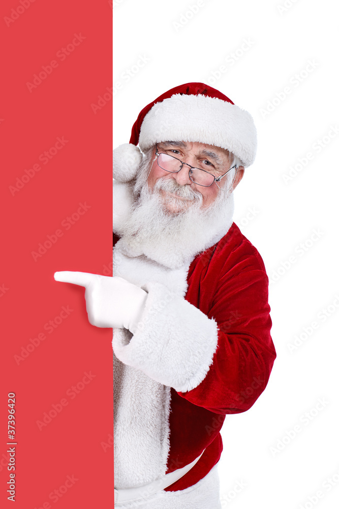 Naklejka premium Santa claus pointing at blank banner