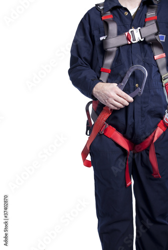 man wearing coveralls and fall protection harness and lanyard