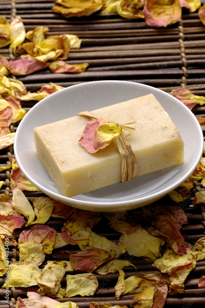 Bowl of soap with rose petals on bamboo mat Bowl of soap with rose petals on bamboo mat