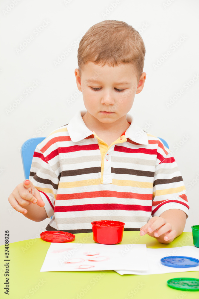 Little boy paints paints sitting at the table Little boy paints paints sitting at the table