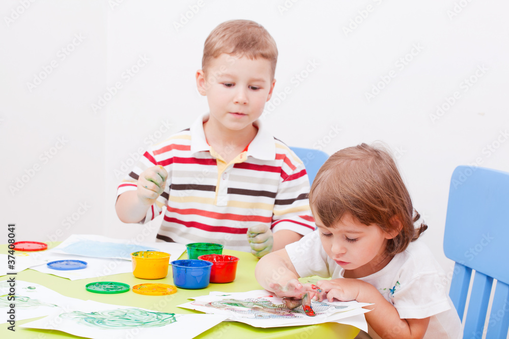 Fototapeta premium brother and the sister draw finger-type paints