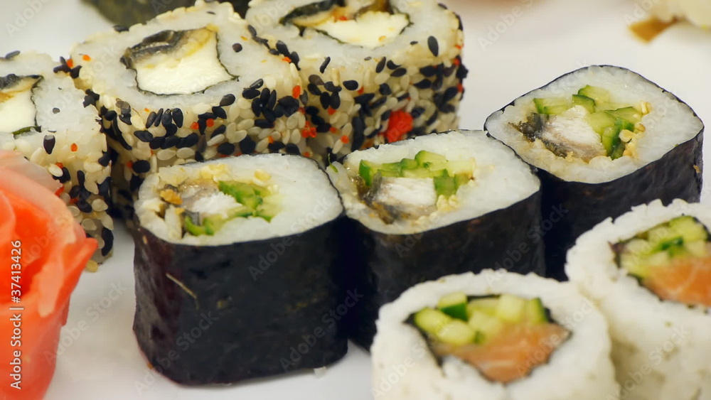 rotating Sushi and rolls on a white plate rotating Sushi and rolls on a white plate
