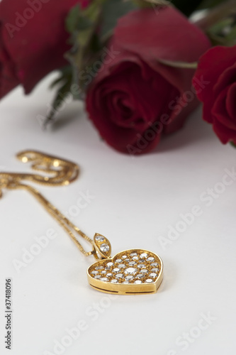 Heart pendant with diamond and red rose on white background