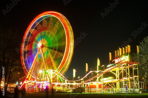 Amusement park at night - ferris wheel and rollercoaster