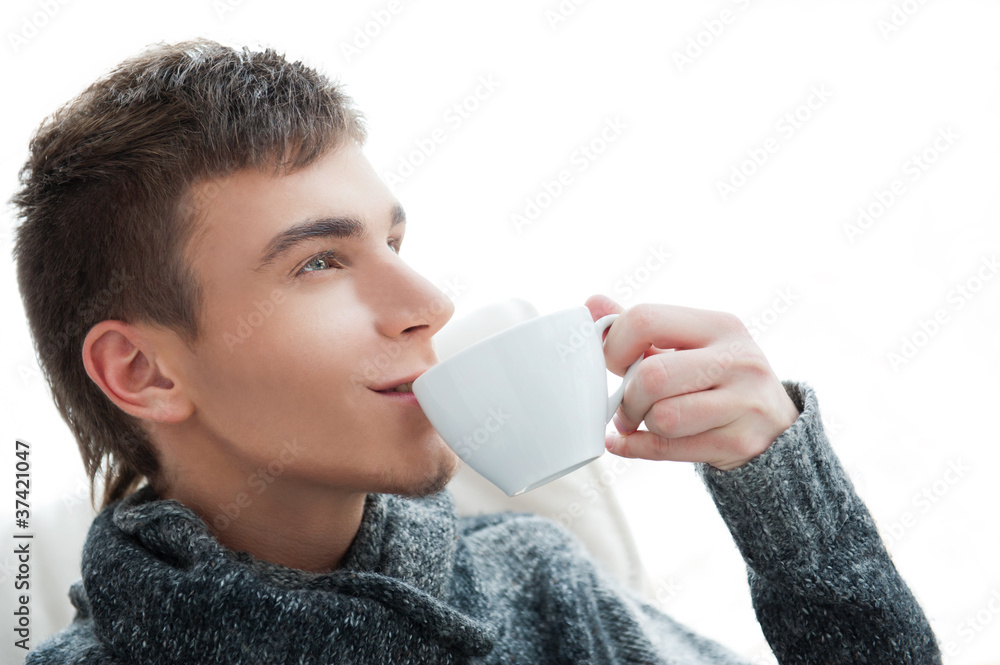 Portrait of a young man drinking coffee and looking away Portrait of a young man drinking coffee and looking away