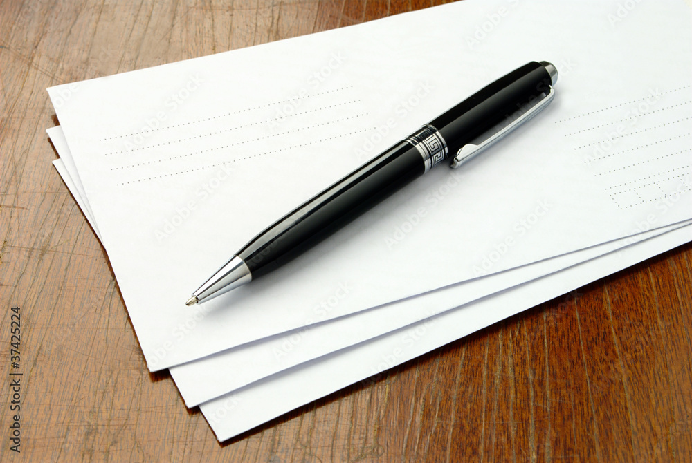 envelopes and a pen envelopes and a pen