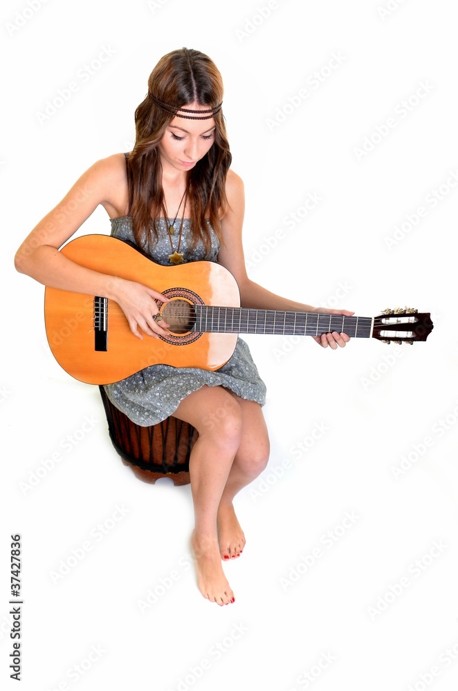 Une belle jeune femme avec une guitare acoustique Photos | Adobe Stock