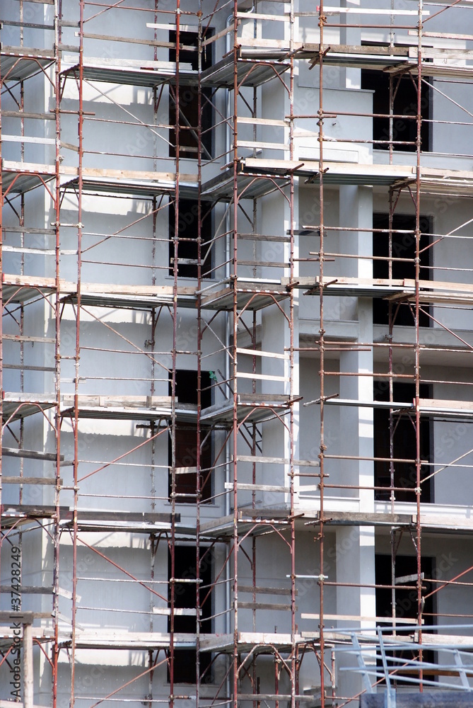 building under construction with rusted scaffold