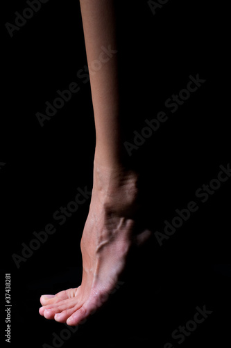Bare foot on a black background