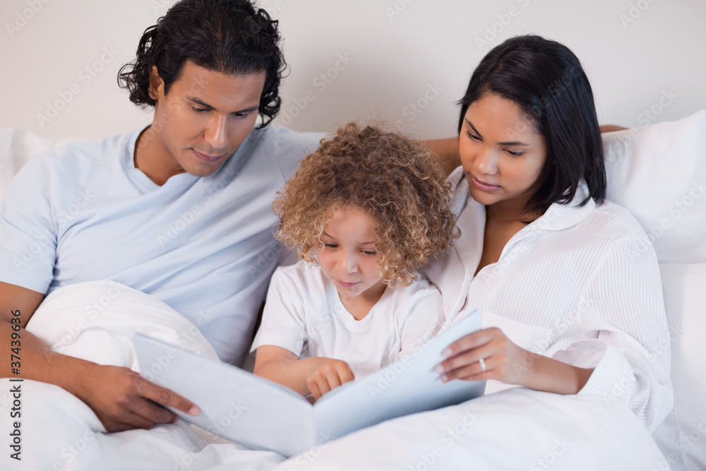 Happy family enjoys reading a book together Happy family enjoys reading a book together