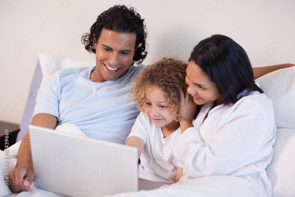 Family in the bedroom surfing the internet Family in the bedroom surfing the internet