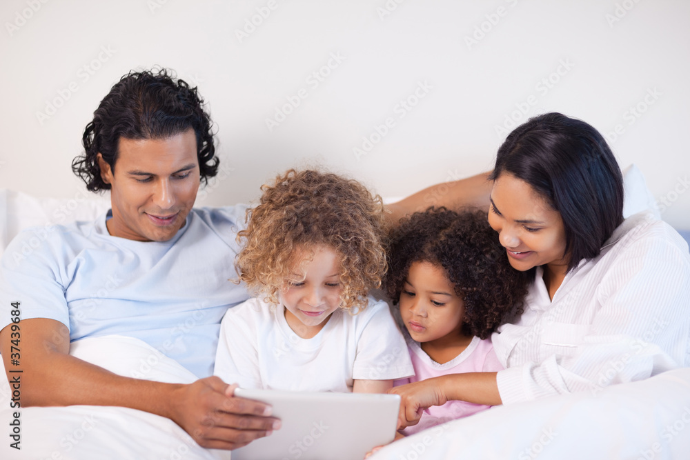 Family sitting on the bed surfing the web Family sitting on the bed surfing the web