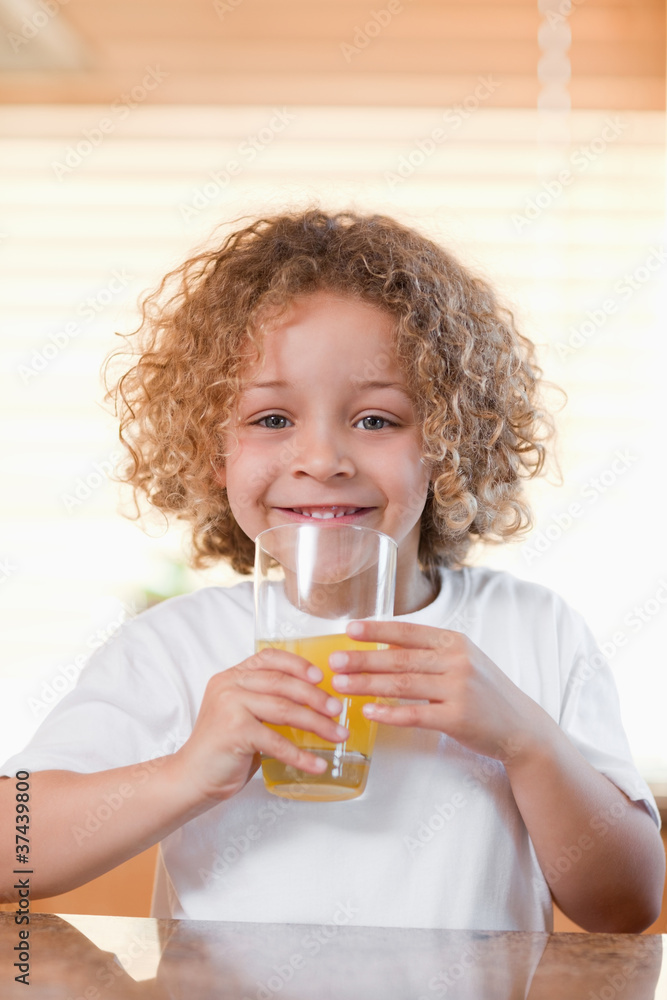Happy girl drinking orange juice in the kitchen Happy girl drinking orange juice in the kitchen