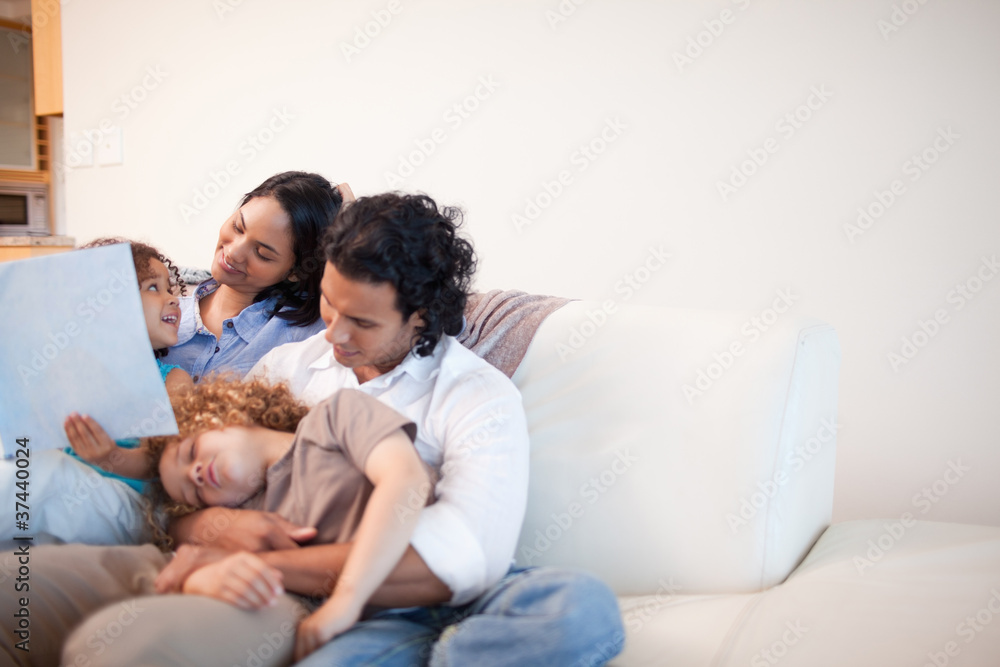 Family in the living room looking at photo album together Family in the living room looking at photo album together