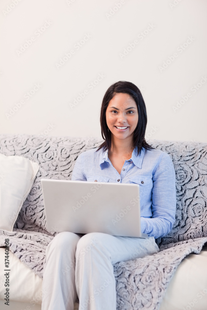 Smiling woman on the sofa surfing the internet Smiling woman on the sofa surfing the internet