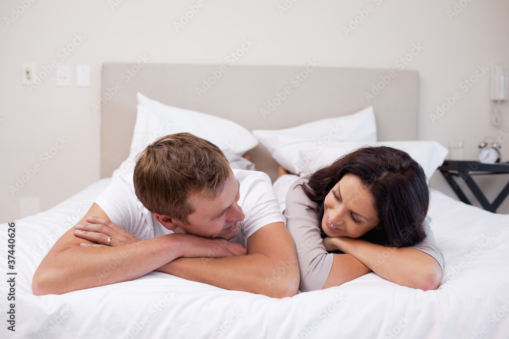 Couple laying on the bed looking at each other Couple laying on the bed looking at each other
