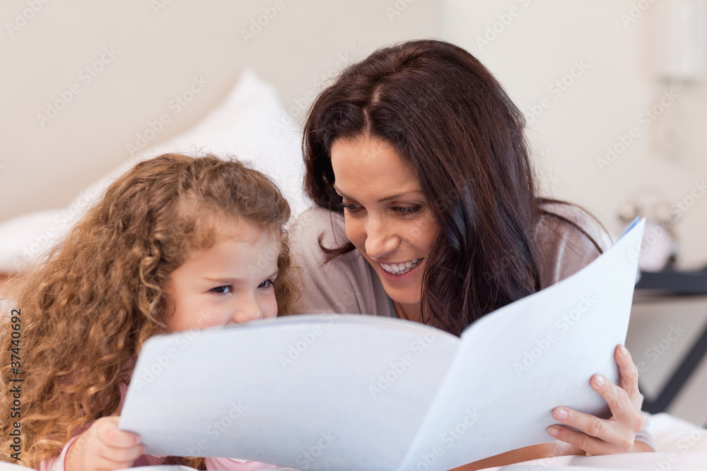 Mother and daughter reading a book together Mother and daughter reading a book together