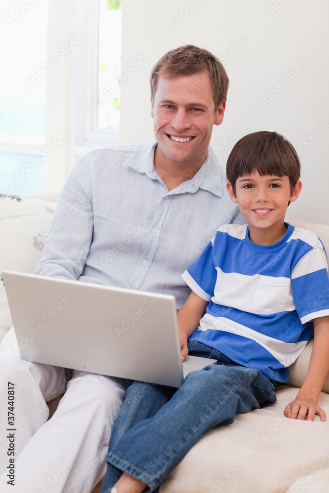 Smiling father and son surfing the internet together Smiling father and son surfing the internet together