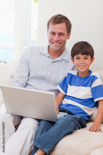 Smiling father and son surfing the internet together