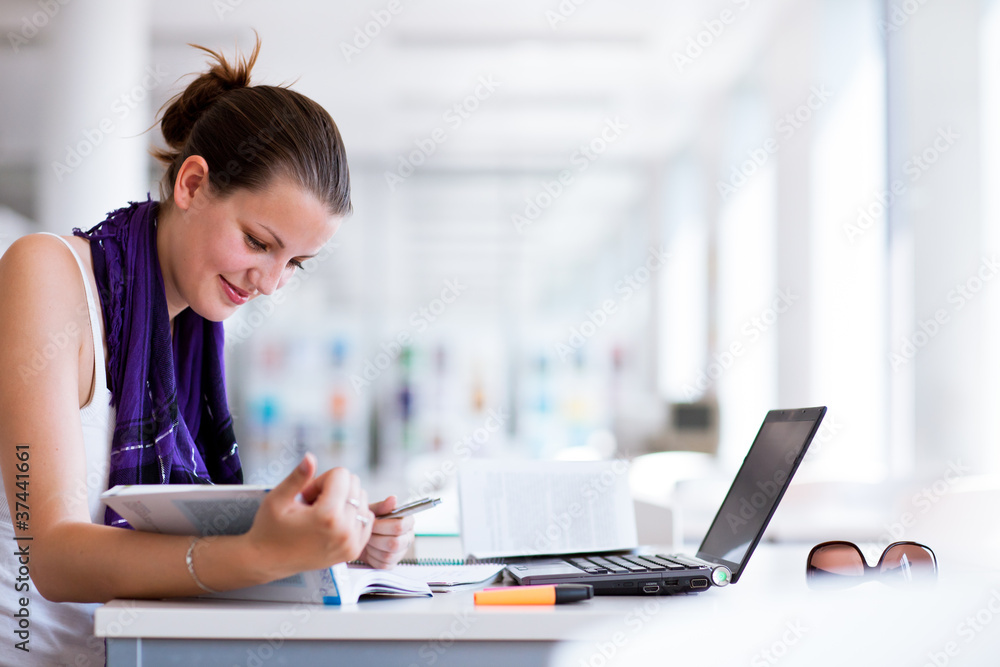 pretty female college student studying in the university library pretty female college student studying in the university library