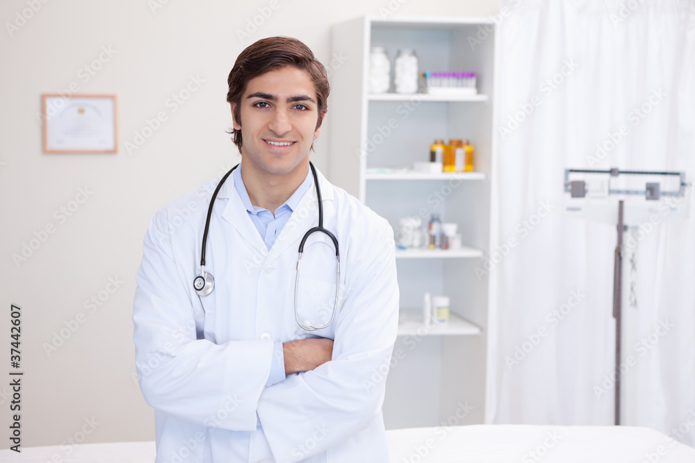 Male doctor standing with arms folded Male doctor standing with arms folded