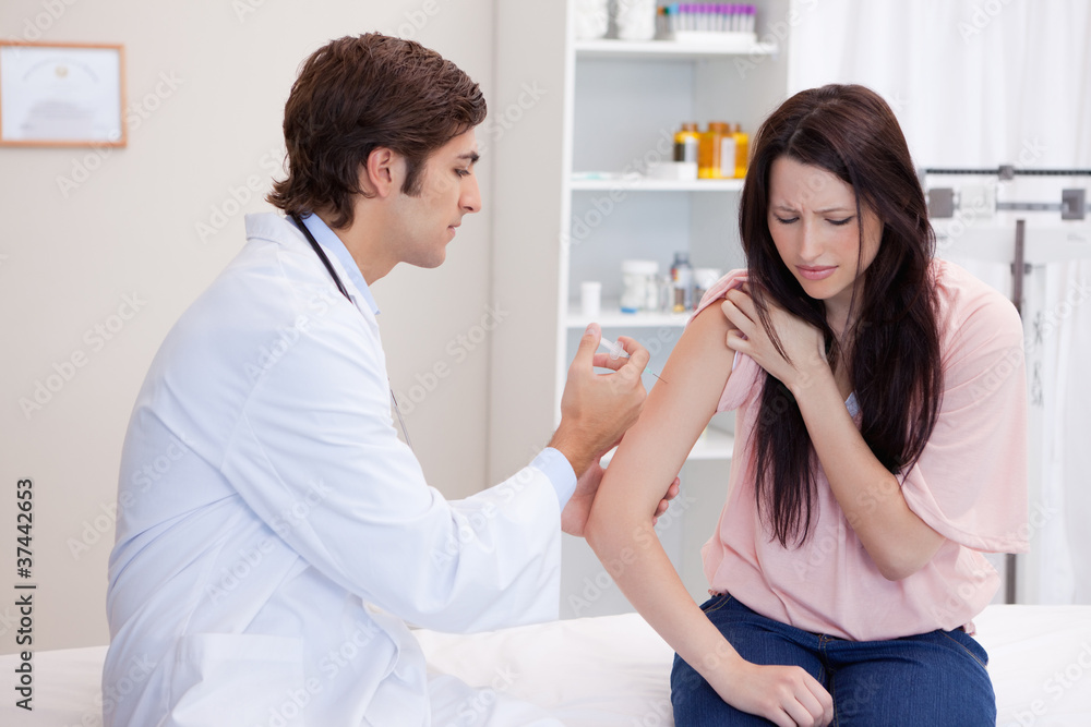 Male doctor giving patient an injection Male doctor giving patient an injection