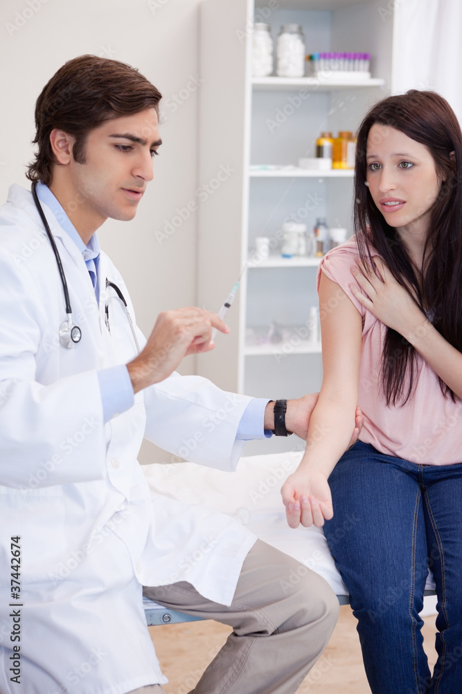 Doctor about to give an injection to patient Doctor about to give an injection to patient