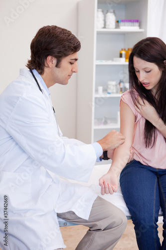 Doctor prepares patients arm for injection