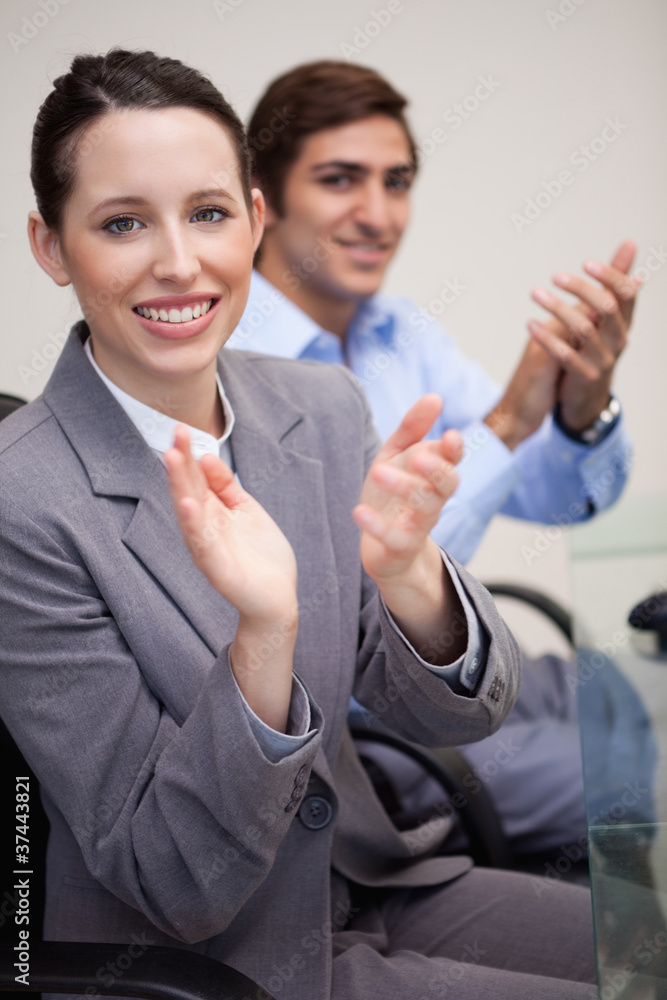 Side view of clapping business team sitting at desk Side view of clapping business team sitting at desk