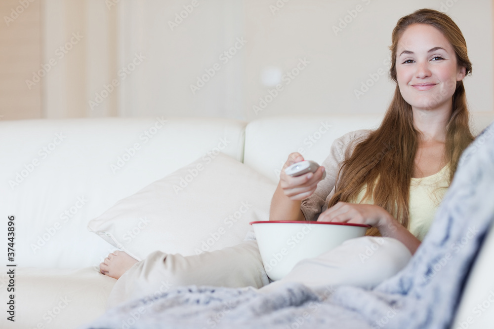 Smiling woman enjoying a movie with a bowl of popcorn Smiling woman enjoying a movie with a bowl of popcorn