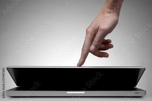 Hand closing laptop on white photo