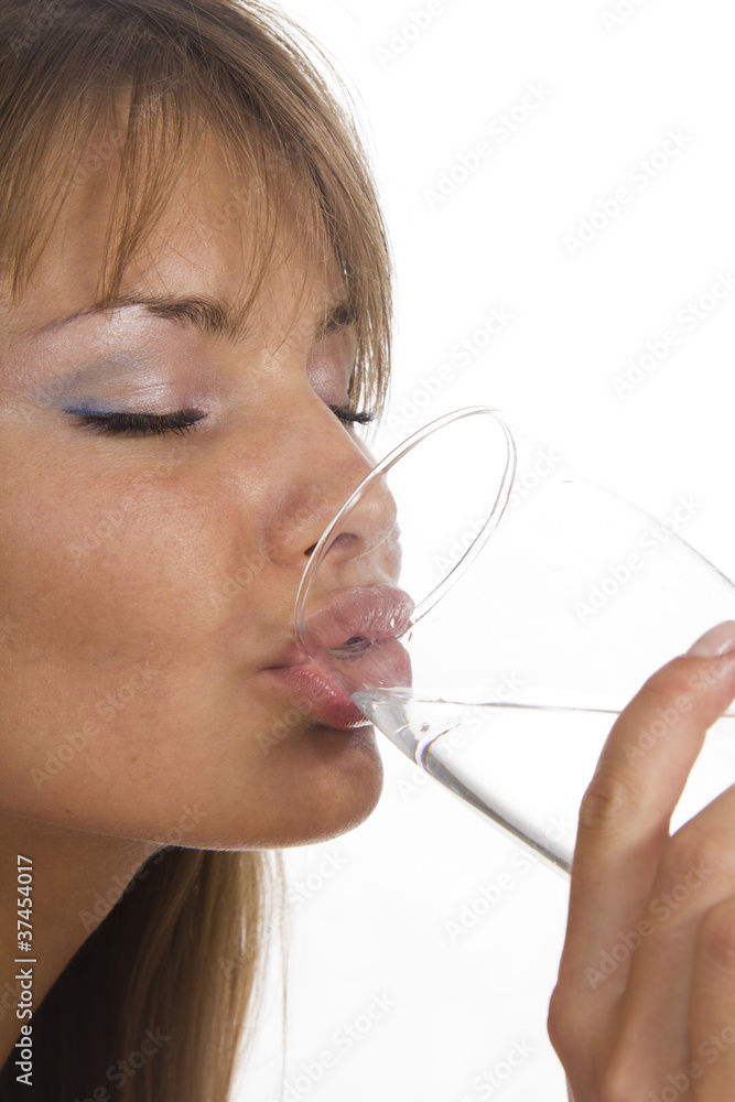Young woman holds glass and girl drinks water. Isolated backgrou Young woman holds glass and girl drinks water. Isolated backgrou