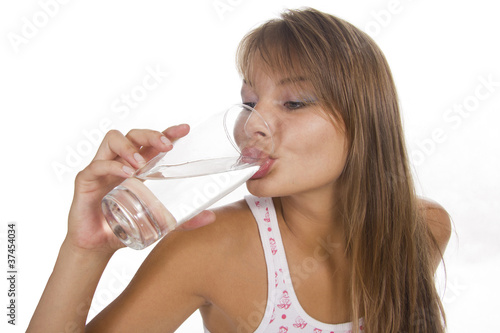 Young woman holds glass and girl drinks water. Isolated backgrou
