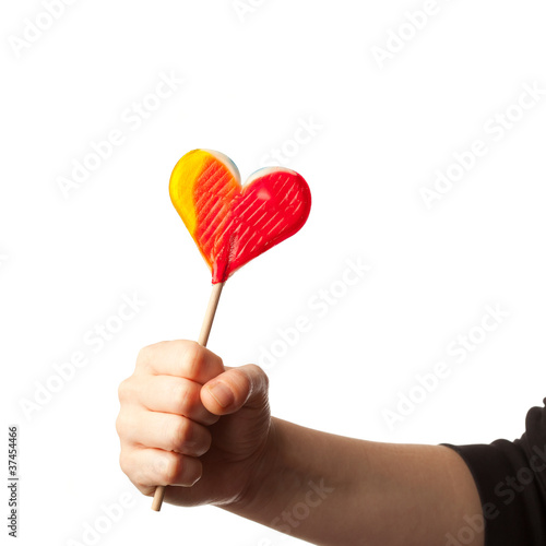 hand holding candy heart isolated on white
