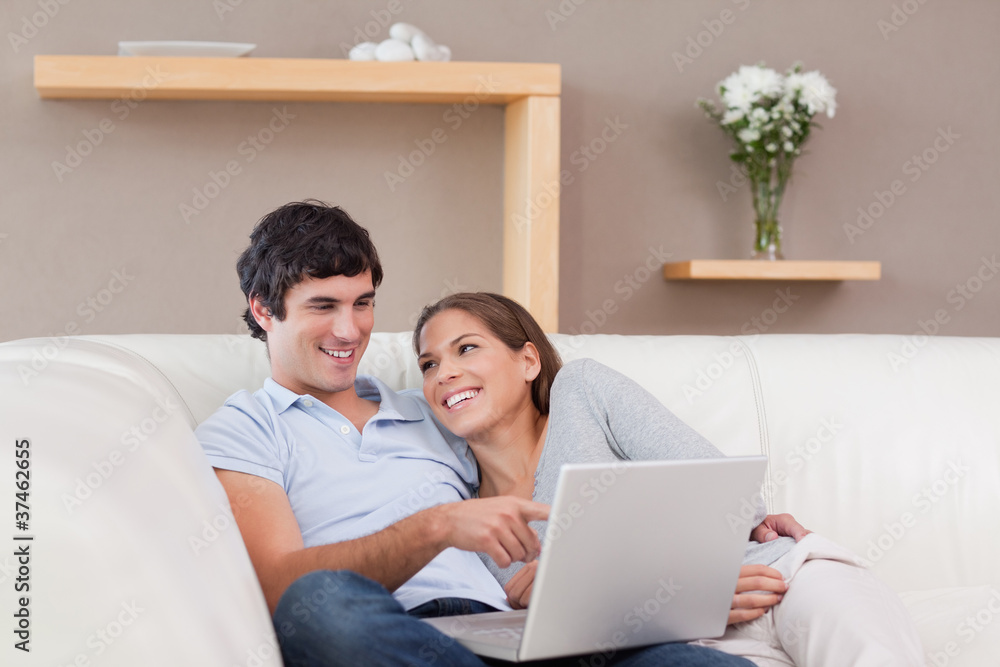Couple with their notebook on the sofa Couple with their notebook on the sofa