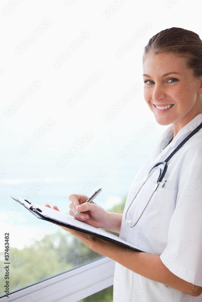 Side view of smiling doctor with clipboard