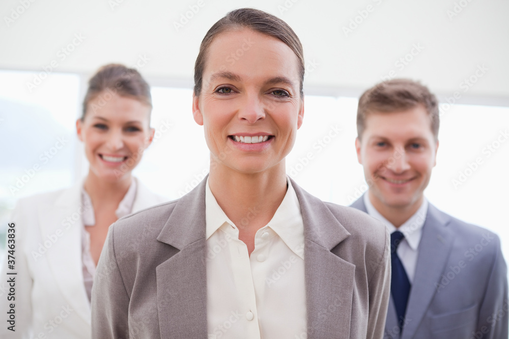 Business consultant with her team behind her Business consultant with her team behind her