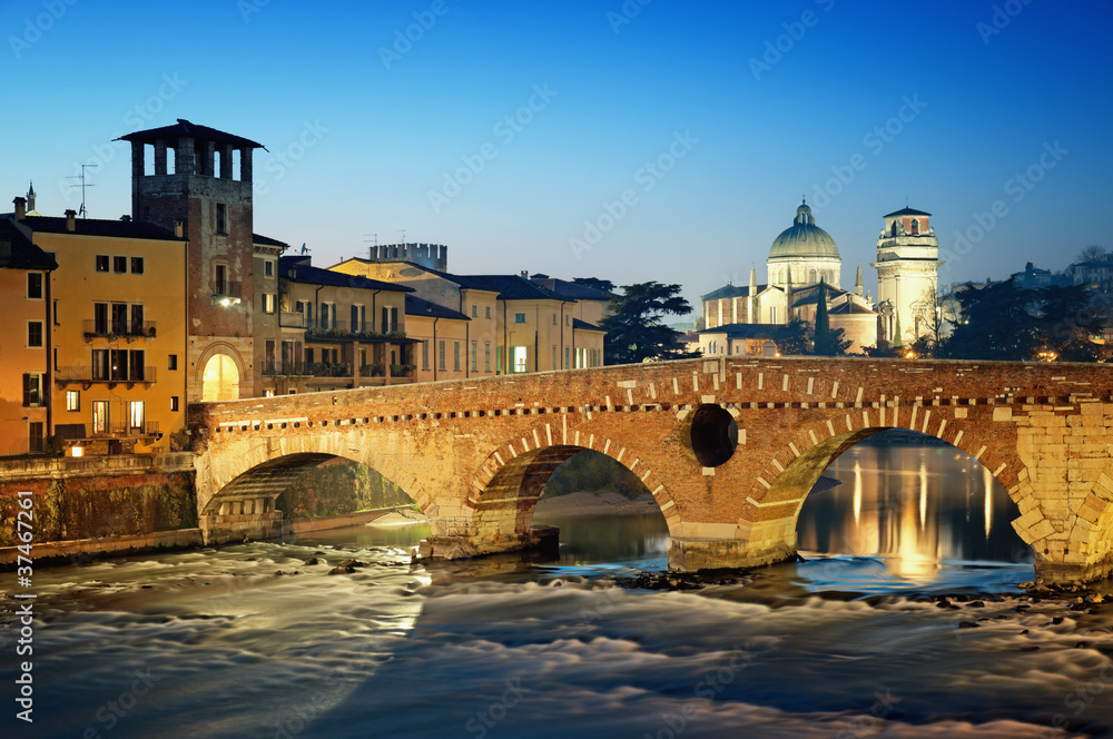 Ponte Pietra and the River Adige at night..