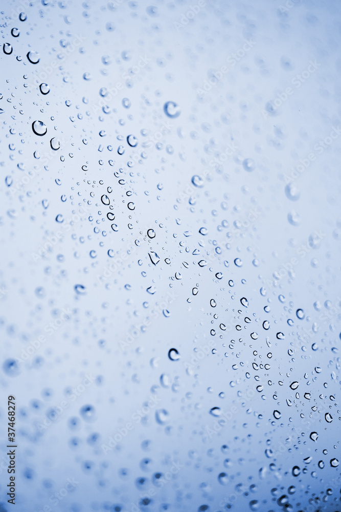Beautiful abstraction with water drops over blue glass backgroun