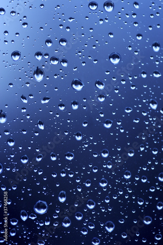 Beautiful abstraction with water drops over blue glass backgroun